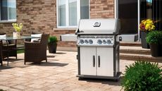 Napoleon Prestige Pro 825 grill on patio area beside outdoor dining table and chairs