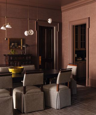 dining area with textured brown walls and upholstered chairs