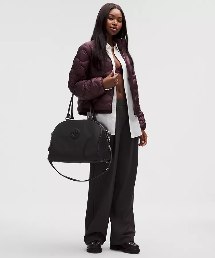 A model holding a black bowling duffle bag.