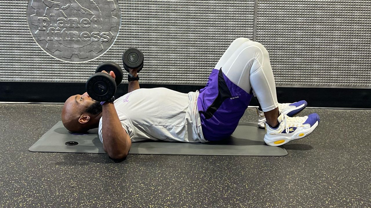 Teddy Savage starting a dumbbell floor chest press to triceps skull crusher