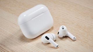 AirPods Pro out of their case on a wooden surface
