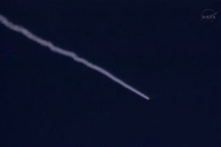 A NASA chase plane captured this view of the IRIS sun telescope and its Pegasus XL rocket as they soar toward orbit from over the Pacific Ocean shortly after launch on June 27, 2013.