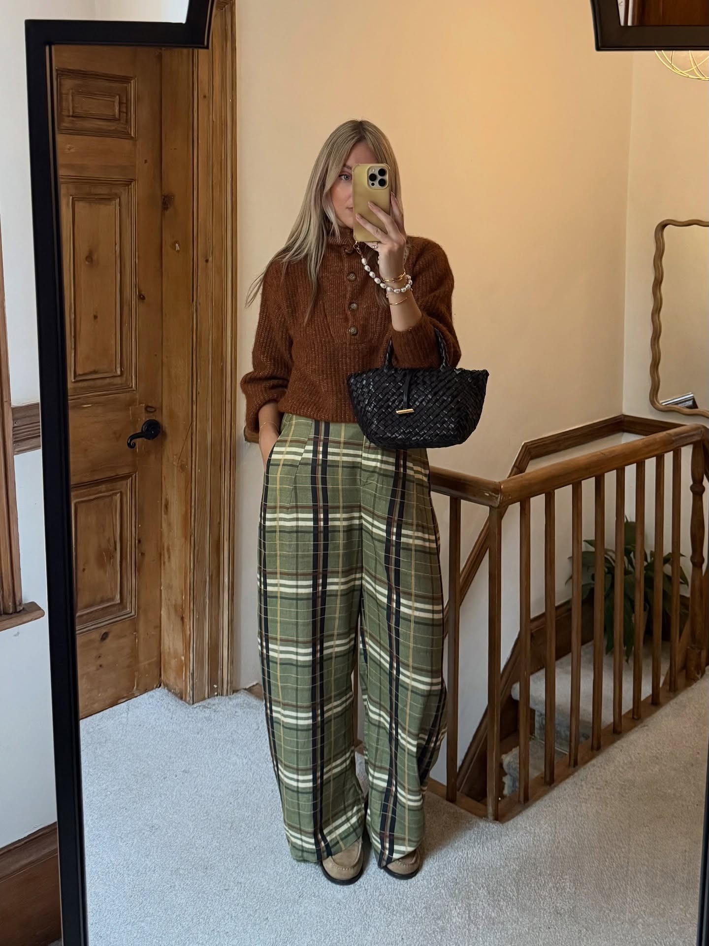Woman in plaid pants and brown sweater