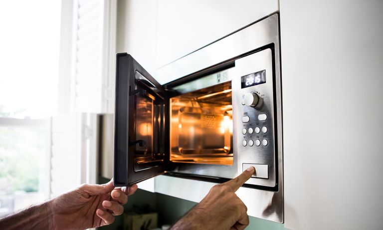 Galanz Air fry Microwave being used in a kitchen – person pressing the on button
