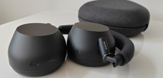 The Sony WH-1000XM6 Bluetooth headphones in black, folded on a white surface with the carry case in the background