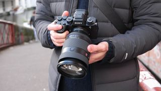 Sony A1 II camera with a Sony FE 28-70mm f/2 GM lens attached held in a person's hands