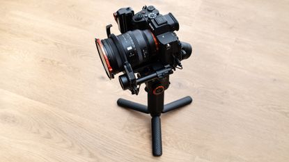 Hohem iSteady MT3 Pro on a wooden floor with the follow focus motor attached