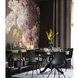 room with floral printed wall and black round table and chairs