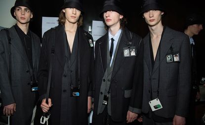 Four young men wearing Prada clothing.
