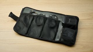 A pair of Shure MoveMic Two wireless microphones and a receiver, placed in the mesh pockets of a padded neoprene roll-up case