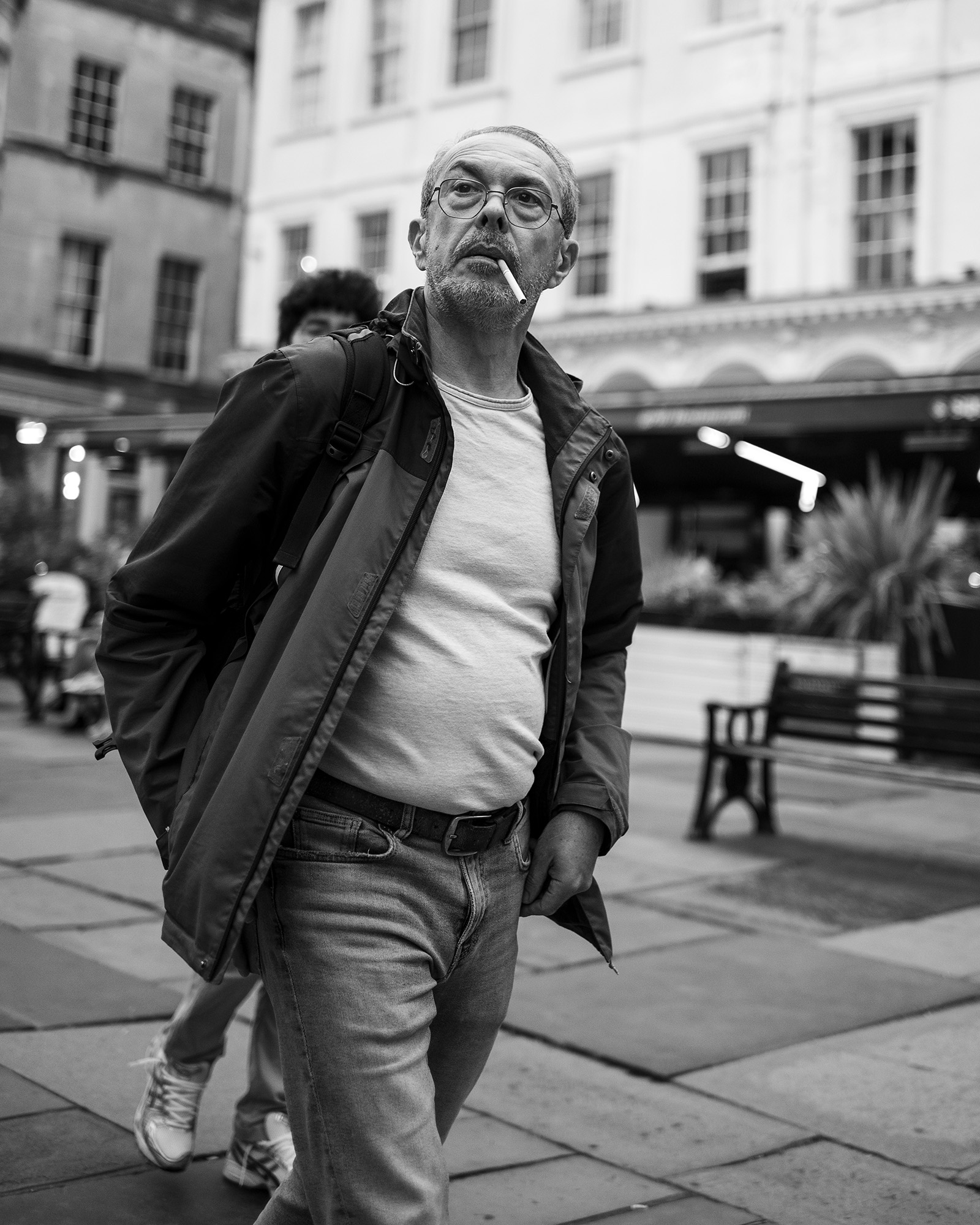 Black and white street photograph of man walking past