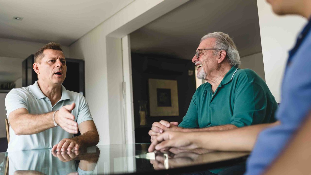 3 men at a table having an animated discussion