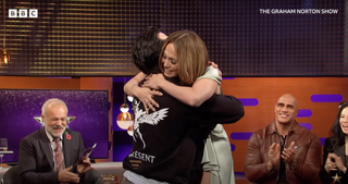 Jennifer Lopez hugging a fan on the set of the Graham Norton Show as Graham Norton, Dwayne Johnson and Lucy Liu smile and clap behind her