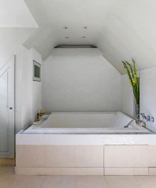 bathroom with bath tub and tiles flooring