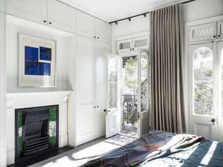 Cabinets that frame a fireplace and mantelpiece area and stretch to the ceiling
