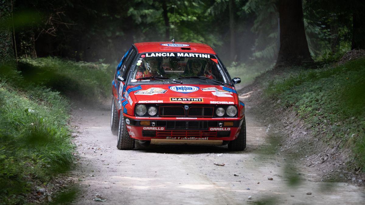 A rally car turning the corner of a race track at Goodwood
