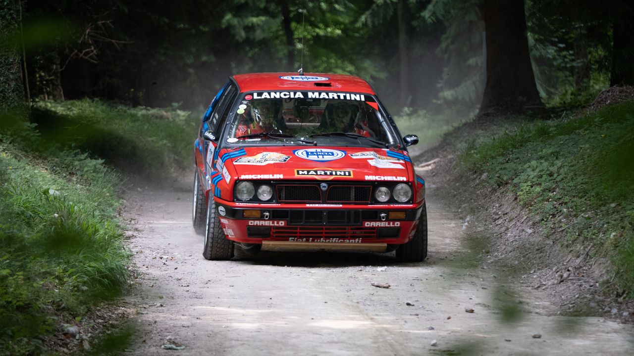 A rally car turning the corner of a race track at Goodwood