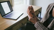 Person with arthritis pain massaging hand