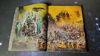 Double-page spread of Necrons vs Aeldari against a starry background
