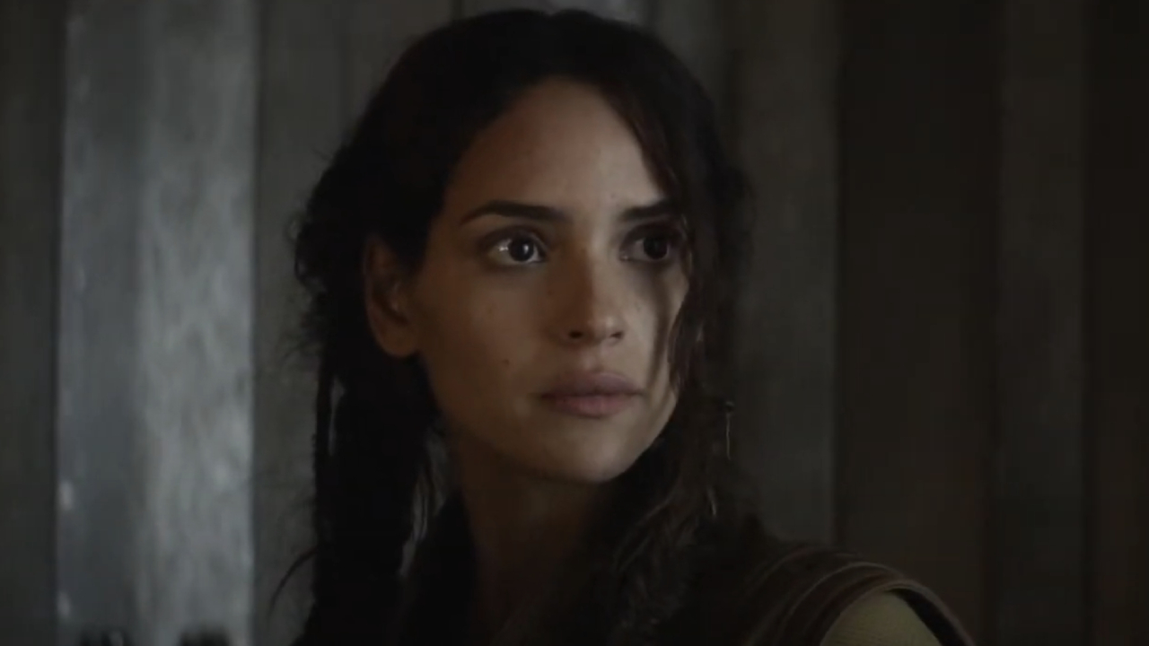 Adria Arjona as Bix Caleena standing in front of a gray wall in Andor