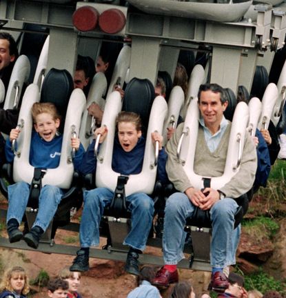 Young prince Harry and Prince William riding a suspended rollercoaster with a friend and their bodyguard Graham Craker in 1994