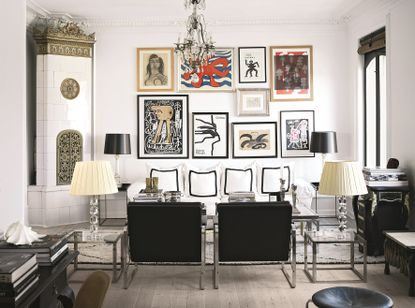 A living room with an eclectic gallery wall, black and white furniture, and a large sofa