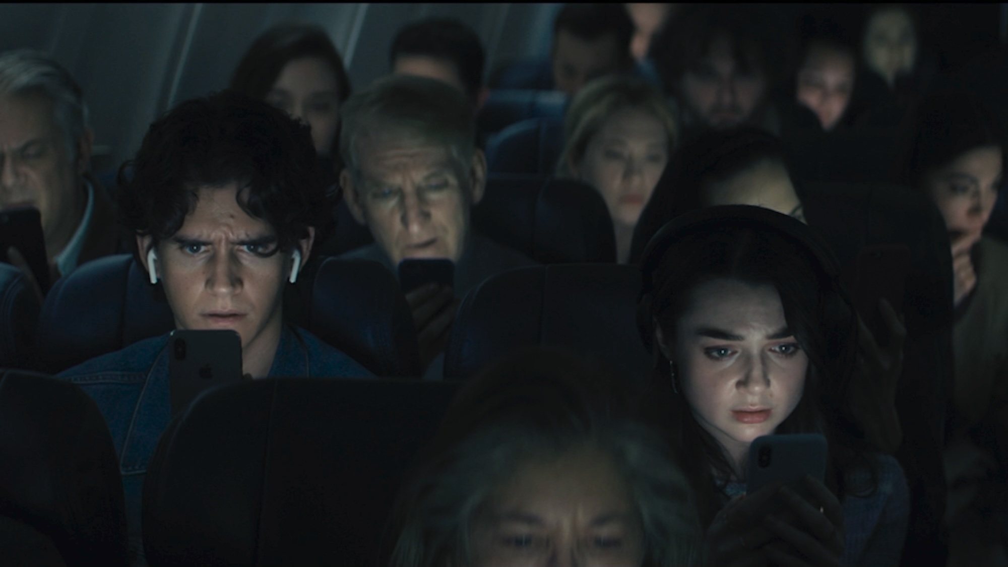 People on a plane watching the broadcast in Disclosure Day