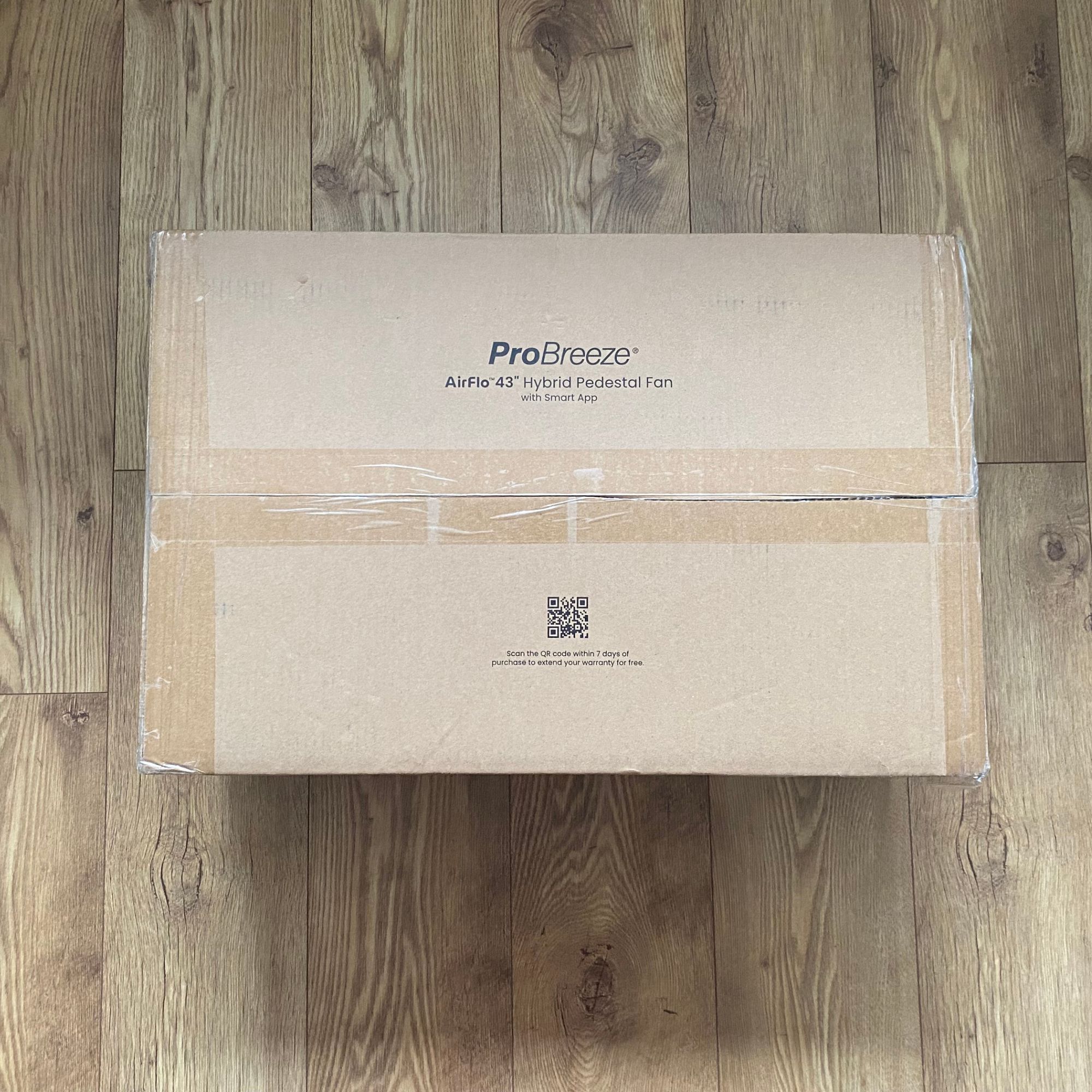Outer packaging of the Pro Breeze Airflo 43'' Hybrid Pedestal Fan on a wooden floor