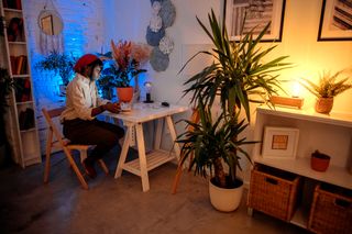 How to protect your eyes as a digital artist; a woman sits in a dimly lit room with a computer