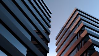 Two modern buildings with glass windows at sunset