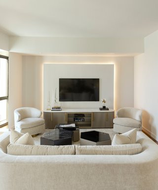 Neutral cream living room with plush curved couches and central television