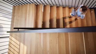 Woman walking up the wooden stairs at home