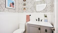 Black and white bathroom with wall art, wall plates, a toilet, and a sink