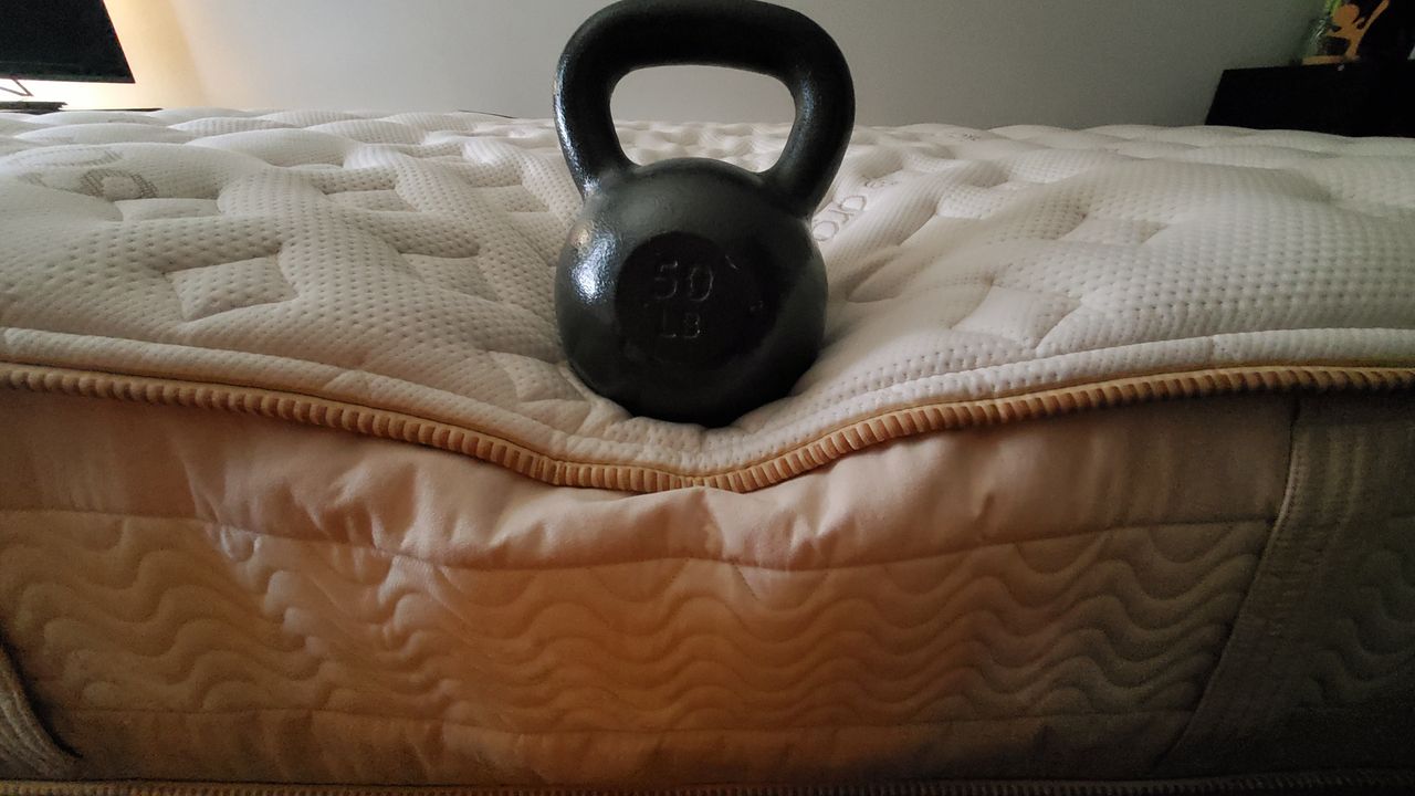 Saatva RX mattress review testing the edge support with a 50lb weight.