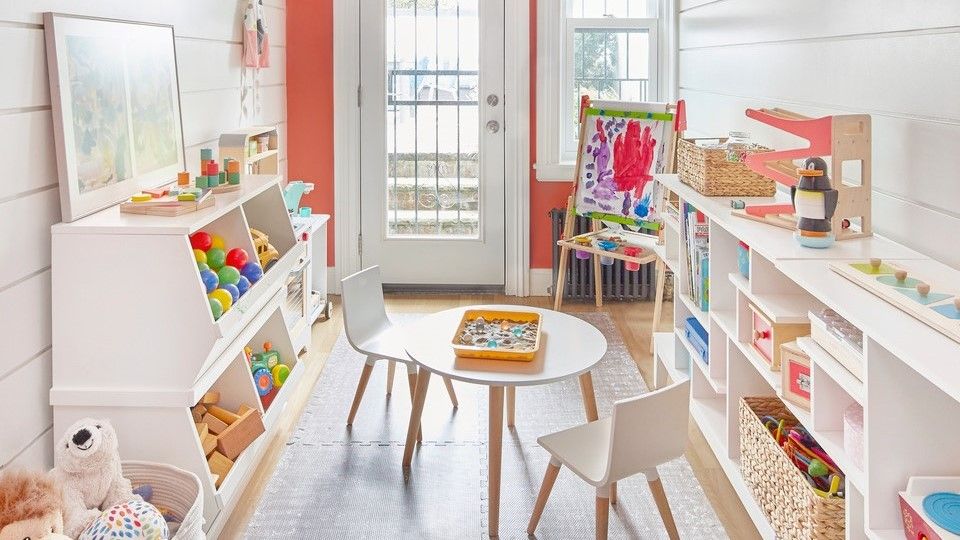 A playroom with orange walls and white furniture