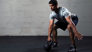 An athletic man working out with a kettle bell