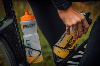Image shows a rider grabbing a water bottle as part of their winter training nutrition strategy
