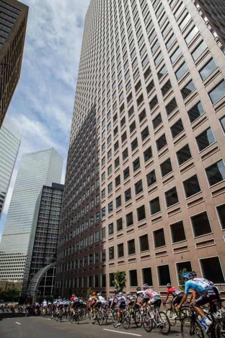 The peloton heads through the tall buildings of downtown Denver.