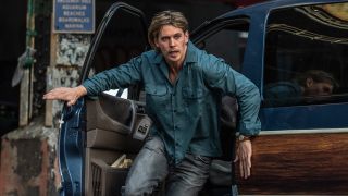 Austin Butler runs out of a car in Caught Stealing
