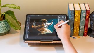 Someone drawing with an Apple pencil on an iPad stand