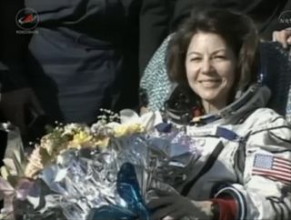 NASA astronaut Cady Coleman smiles and holds flowers presented to her after she and crewmates landed back on Earth on May 23, 2011. The Soyuz TMA-20 space capsule carrying Coleman and her two Expedition 27 crewmates landed in Kazakhstan to end their 157-day mission to the International Space Station.