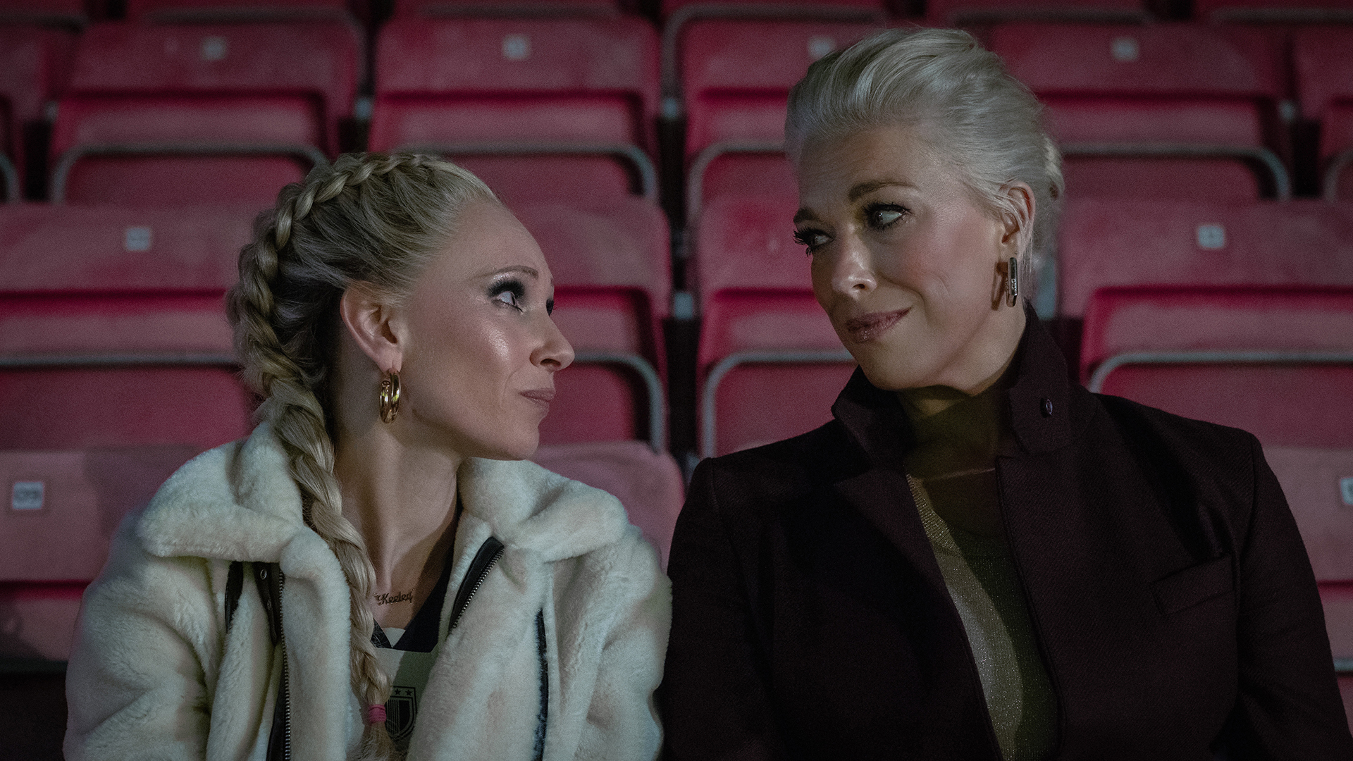 Keely and Rebecca looking at each other as they sit in a football stadium in Ted Lasso season 4 episode 4