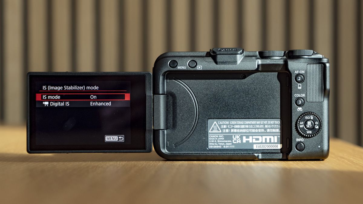 Rear of the Canon EOS R50 V, on a wooden table, screen flipped out to the side