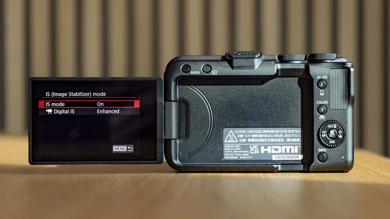 Rear of the Canon EOS R50 V, on a wooden table, screen flipped out to the side