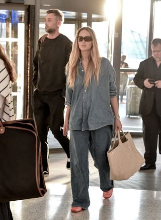 Jennifer Lawrence at JFK Airport wearing the double denim trend mesh flats and a big tote bag