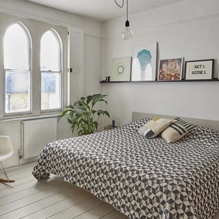 main bedroom with white arched windows and wooden flooring