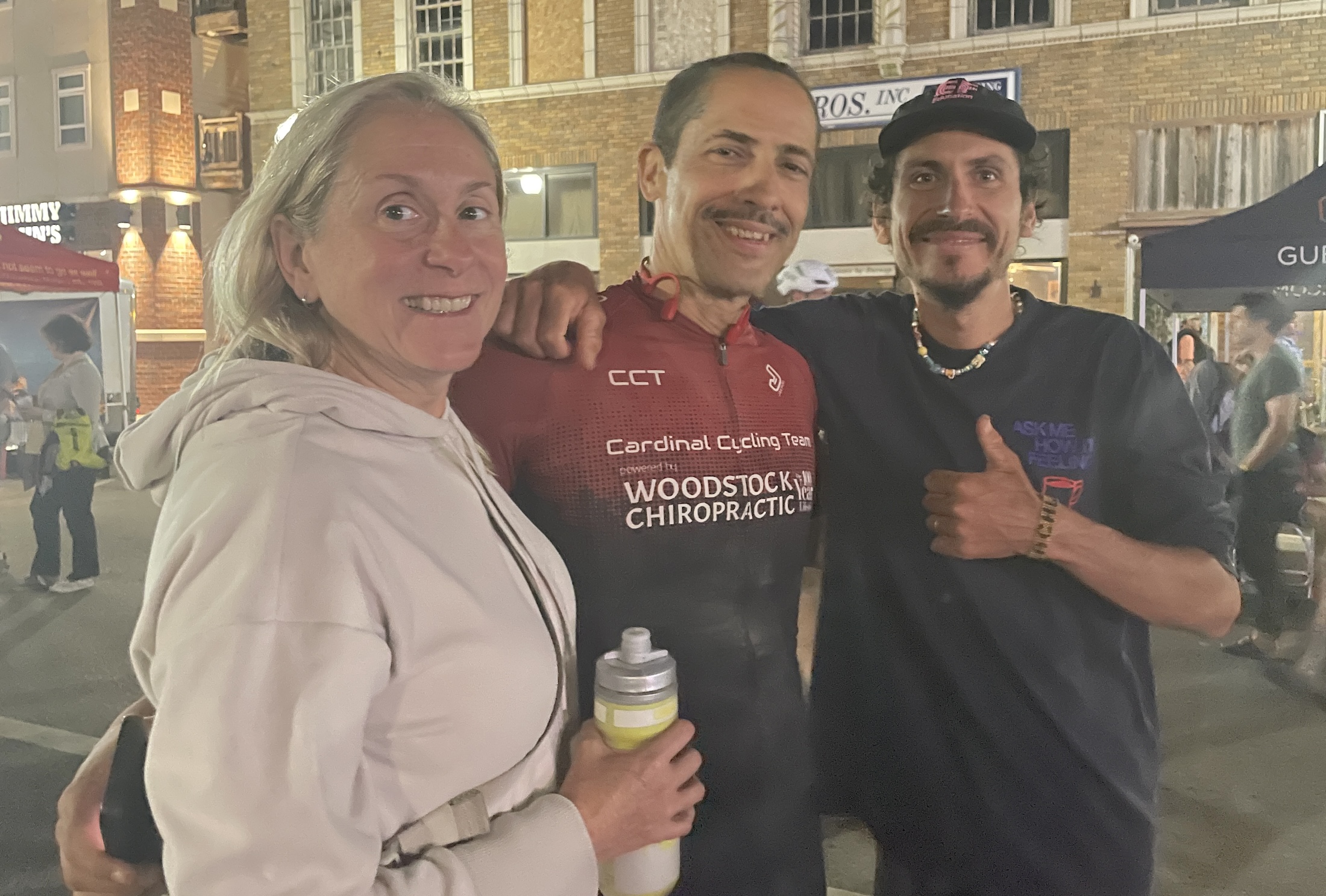 Lachlan Morton poses for a photo with Harold Sotillo and his wife Lynn of Woodstock, Georgia, Harold having just finished his 200-mile ride almost four hours after Morton