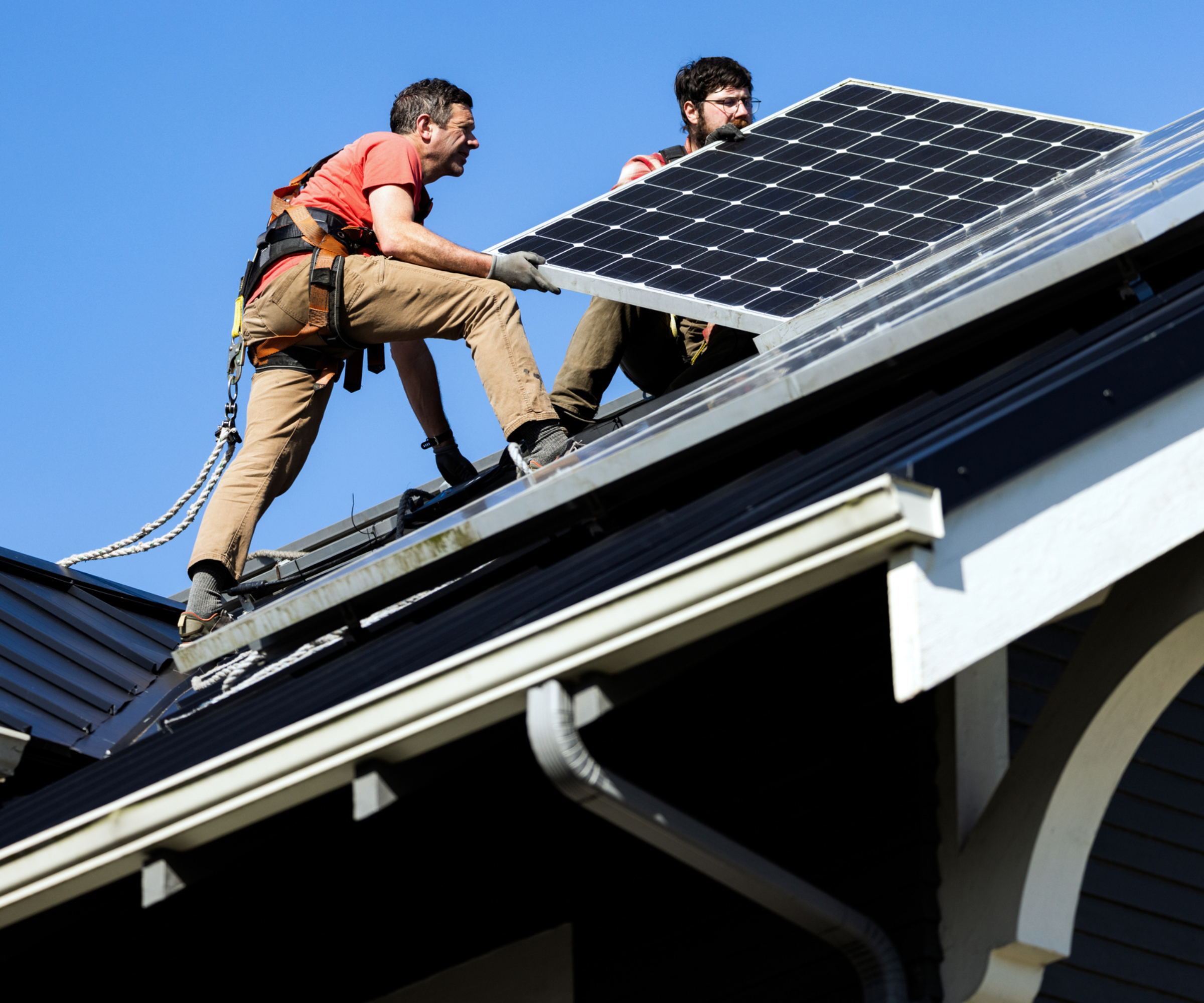 solar panel installers placing solar panels on roof