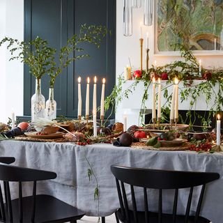 Dining table with foliage, fruit and tapered candles