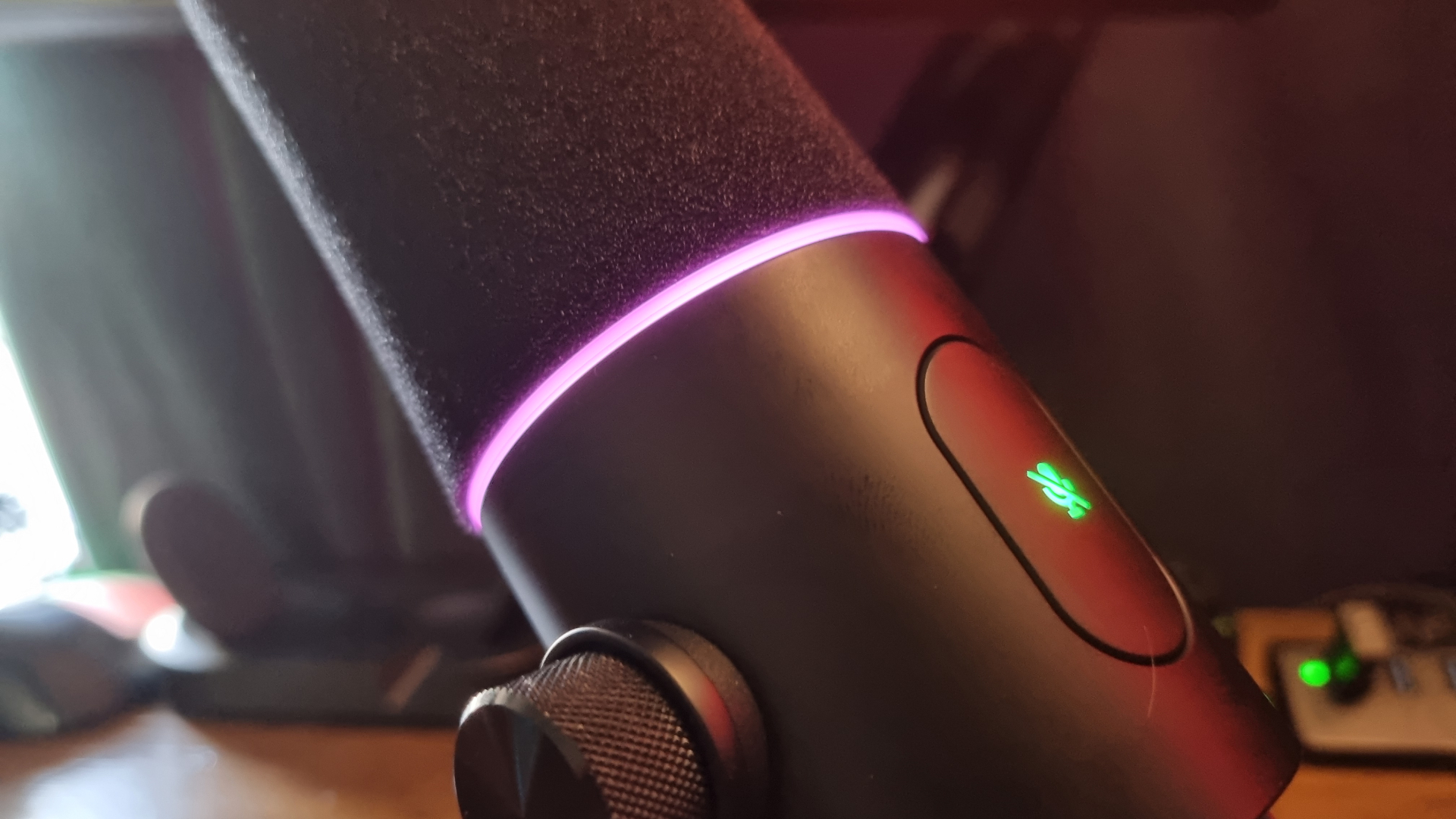 A Razer Seiren V3 Pro in close up, showing the mute button and RGB ring